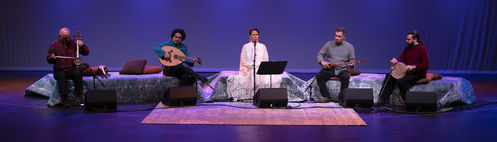 Parissa performing on stage with accompanying musicians 